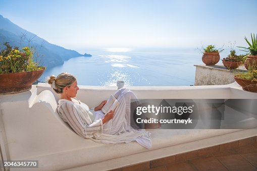Woman reading a book on a villa balcony or terrace in Praiano Italy. Woman reading a book on a villa balcony or terrace in Praiano Italy.