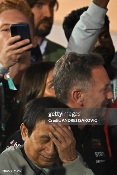 Thai businessman Chalerm Yoovidhya gestures next to Red Bull Racing team principal Christian Horner during the podium ceremony of the Bahrain Formula...