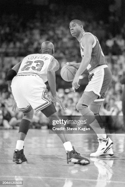 View of American basketball player Michael Jordan , of the Chicago Bulls, and Magic Johnson , of the Los Angeles Lakers, on the court during the...