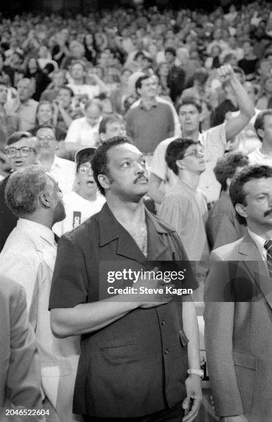View of American minister, politician, and Civil Rights leader Reverend Jesse L Jackson stands during the National Anthem before the first game of...