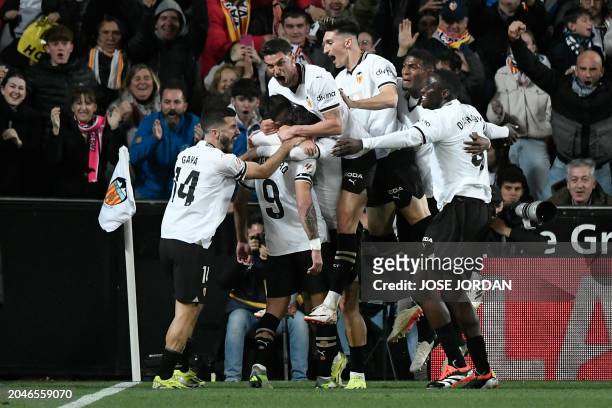 Valencia's players celebrates scoring their team's first goal during the Spanish league football match between Valencia CF and Real Madrid at the...