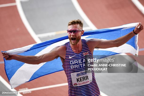 First-placed Britain's Josh Kerr celebrates with the Scottish flag after winning the Men's 3000m final during the Indoor World Athletics...