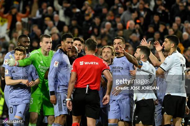Spanish referee Jesus Gil Manzano talks with Real Madrid's English midfielder Jude Bellingham during the Spanish league football match between...