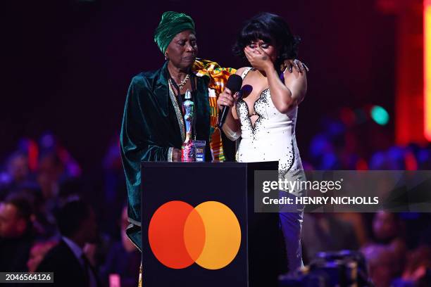 British singer-songwriter RAYE taking the stage with her grandmother, reacts after receiving the album of the year award for "My 21st Century Blues"...