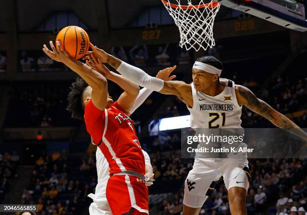 Darrion Williams of the Texas Tech Red Raiders drives the lane against RaeQuan Battle of the West Virginia Mountaineers in the first half at the WVU...