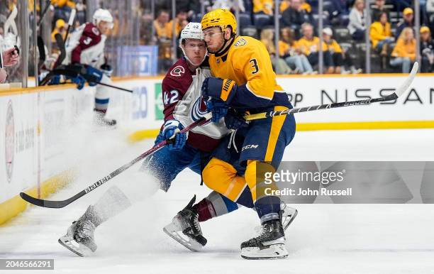 Jeremy Lauzon of the Nashville Predators hits Josh Manson of the Colorado Avalanche during an NHL game at Bridgestone Arena on March 2, 2024 in...