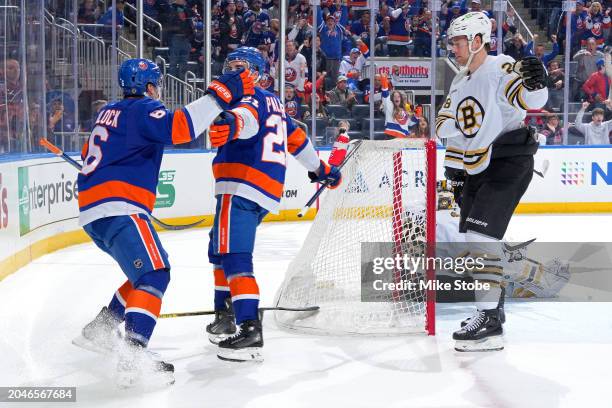 Kyle Palmieri of the New York Islanders is congratulated by Ryan Pulock of the New York Islanders after scoring a natural hat-trick goal past Linus...
