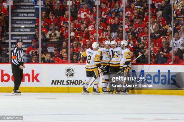 Chad Ruhwedel, Emil Bemstrom and teammates of the Pittsburgh Penguins celebrate a goal against the Calgary Flames at the Scotiabank Saddledome on...