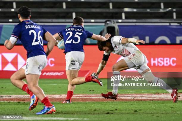 France's Antoine Dupont carries the ball for a try past USA's Steve Tomasin during the 2024 HSBC Rugby Sevens LA tournament match between USA and...