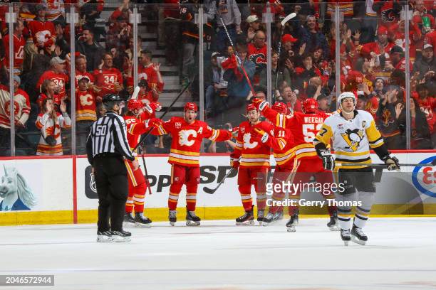Blake Coleman, Mikael Backlund and teammates of the Calgary Flames celebrate a goal against the Pittsburgh Penguins at the Scotiabank Saddledome on...