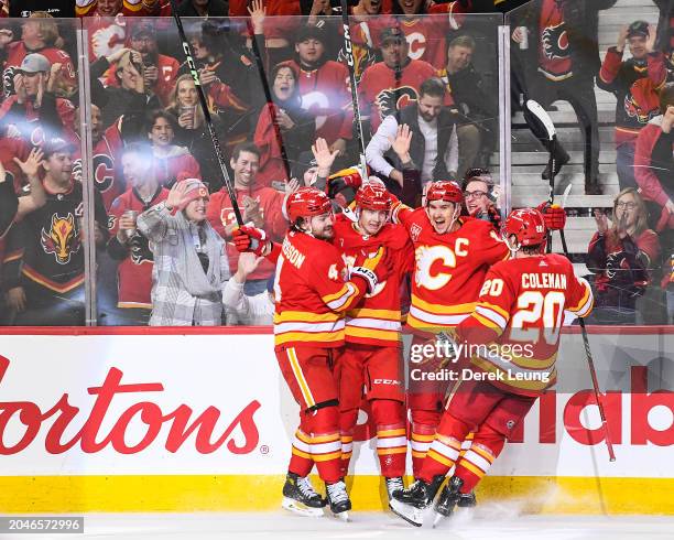 Yegor Sharangovich of the Calgary Flames celebrates with his teammates after scoring the game-winning goal against the Pittsburgh Penguins during the...
