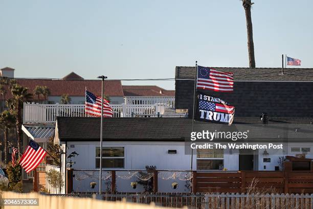 Flag showing support for former President Donald Trump flies amid several American flags in Huntington Beach, Ca. On February 21st, 2024.
