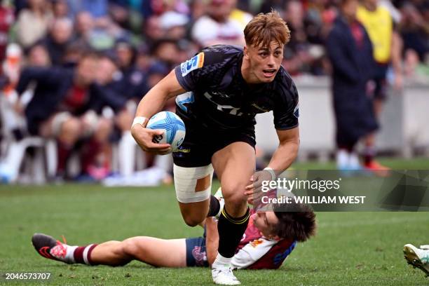 Hurricanes player Ruben Love breaks through a tackle during the Super Rugby match between the Queensland Reds and the Wellington Hurricanes in...