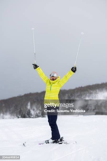 a woman enjoys skiing on her winter vacation. - 札幌市 imagens e fotografias de stock