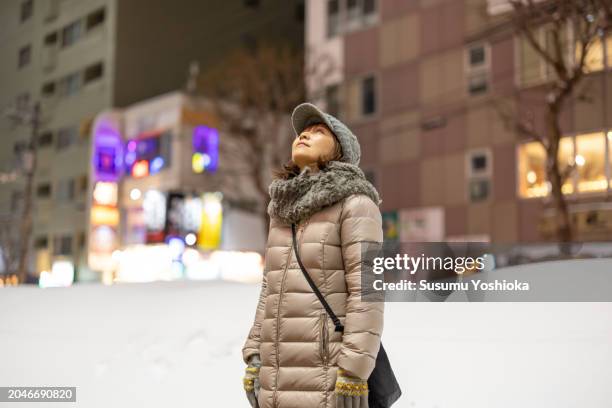 woman on a sightseeing trip to a snowy city on winter vacation. - 札幌市 stock-fotos und bilder