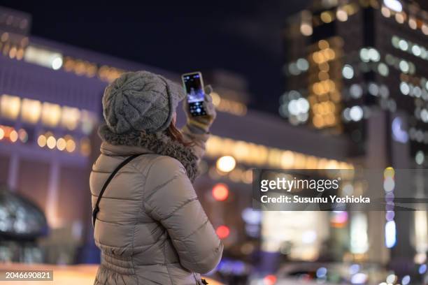 woman on a sightseeing trip to a snowy city on winter vacation. - 札幌市 imagens e fotografias de stock