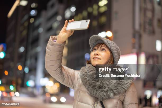 woman on a sightseeing trip to a snowy city on winter vacation. - 札幌市 stock-fotos und bilder