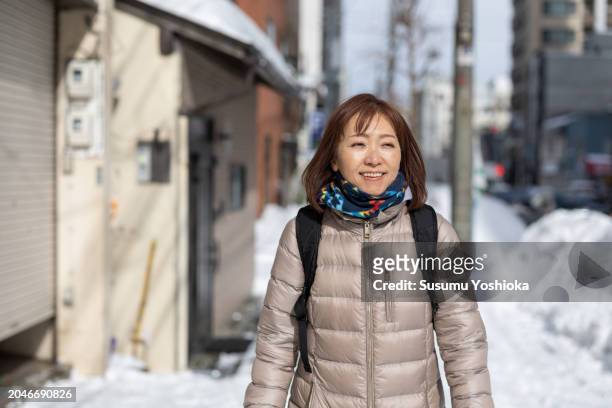 woman on a sightseeing trip to a snowy city on winter vacation. - 札幌市 stock-fotos und bilder