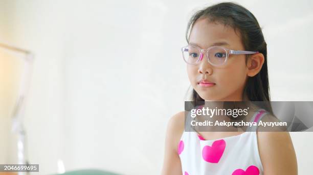 portrait of an asian girl waiting for her initial check-up and looking slightly worried in the hospital. - truehearts stock pictures, royalty-free photos & images