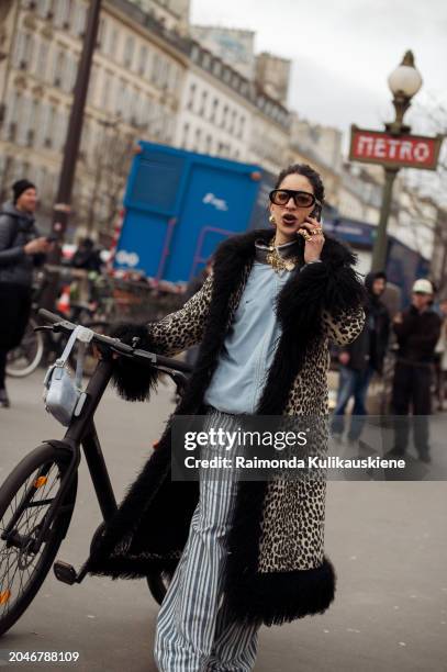 Selma Kaci wears an animal print faux fur coat, light blue top, striped oversized pants, light blue bag, black sunglasses and gold necklaces outside...