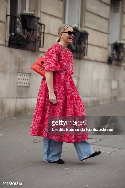 Hollie Mercedes Peters wears red dress, denim jeans, red JW Anderson bag and sunglasses outside Cecilie Bahnsen during the Womenswear Fall/Winter...