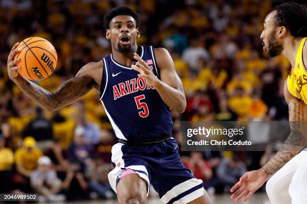 Lewis of the Arizona Wildcats passes around Frankie Collins of the Arizona State Sun Devils during the first half at Desert Financial Arena on...