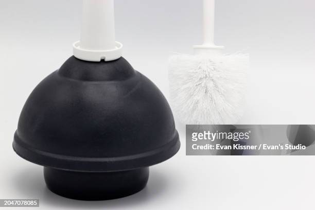 black toilet bowl plunger and a white toilet bowl brush on a white background - plunger stock pictures, royalty-free photos & images