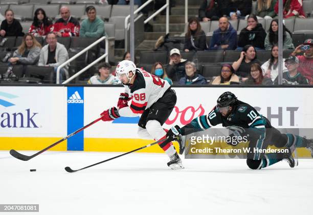 Kevin Bahl of the New Jersey Devils and Anthony Duclair of the San Jose Sharks skates to gain control of the puck in the third period at SAP Center...