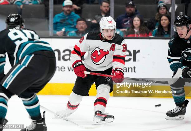 Jack Hughes of the New Jersey Devils skates with the puck against the San Jose Sharks during the third period of an NHL hockey game at SAP Center on...