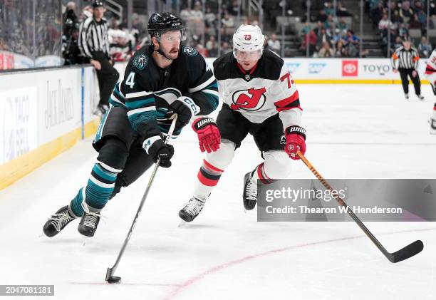 Kyle Burroughs of the San Jose Sharks skating with the puck is pursued by Tyler Toffoli of the New Jersey Devils during the second period of a NHL...