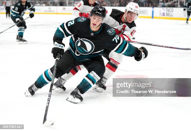 William Eklund of the San Jose Sharks skating with the puck defended by Ondrej Palat of the New Jersey Devils during the second period of an NHL...