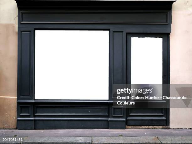 empty facade of a store whose windows have been replaced by white backgrounds in paris, france. weathered walls and sidewalk. sunlight. natural colors.no logo or trademark. - guardare le vetrine foto e immagini stock