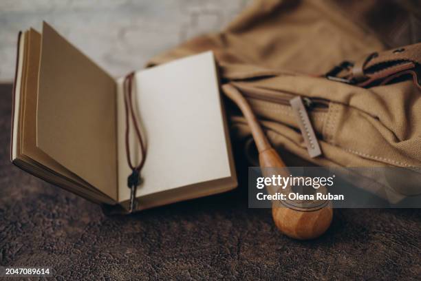 a notebook and a smoking pipe by a handbag. - pipa prodotto a base di tabacco foto e immagini stock