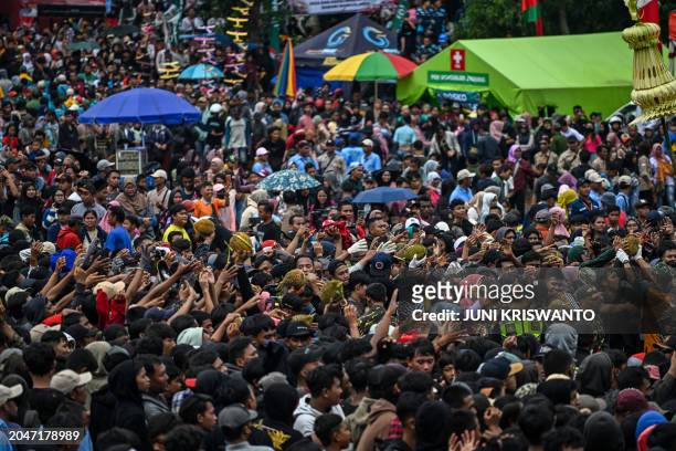 People reach out to claim free durians during the durian festival in Wonosalam village in Jombang, eastern Java Island on March 3, 2024. Grown across...