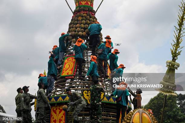 Indonesian volunteers distribute durians to the crowd during the durian festival in Wonosalam village in Jombang, eastern Java Island on March 3,...