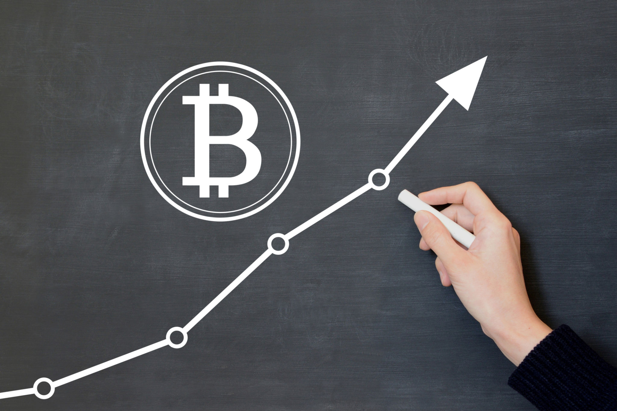 Human's hand drawing bitcoin sign and upward arrow Human's hand drawing bitcoin sign and upward arrow