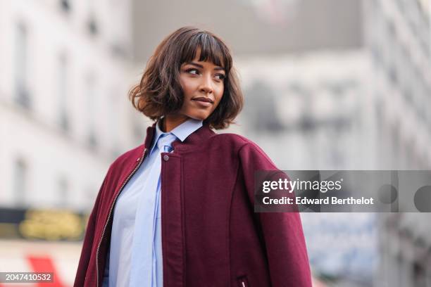 Flora Coquerel wears a burgundy oversized bomber jacket , a pastel pale blue long shirt / midi dress with a tie, outside Casablanca, during the...