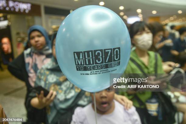 Person holds a balloon during an event held by relatives of the passengers and supporters to mark the 10th year since the Malaysia Airlines flight...