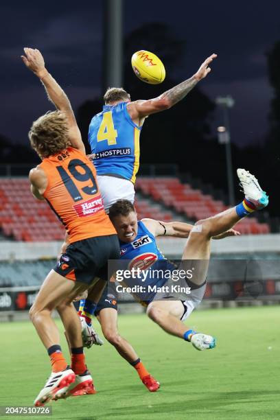 Brandon Ellis and Nick Holman of the Suns compete for the ball against Nick Haynes of the Giants during the 2024 AFL Community Series match between...