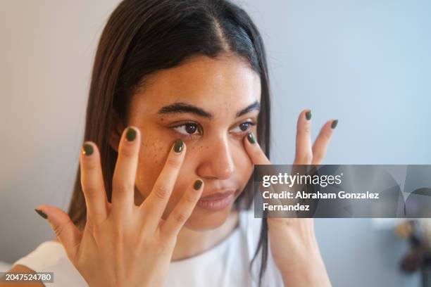 woman applying anti ageing cream to the face - wrinkled stock pictures, royalty-free photos & images