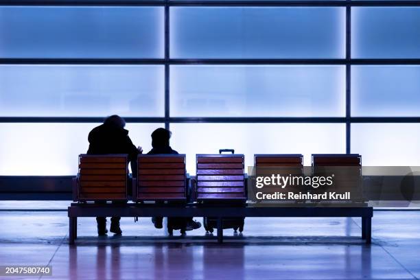 rückansicht von zwei personen, die auf einer bank im u-bahnhof sitzen - reinhard krull stock-fotos und bilder