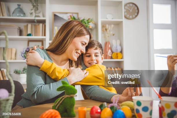 happy family preparing easter at home - happy easter mom stockfoto's en -beelden
