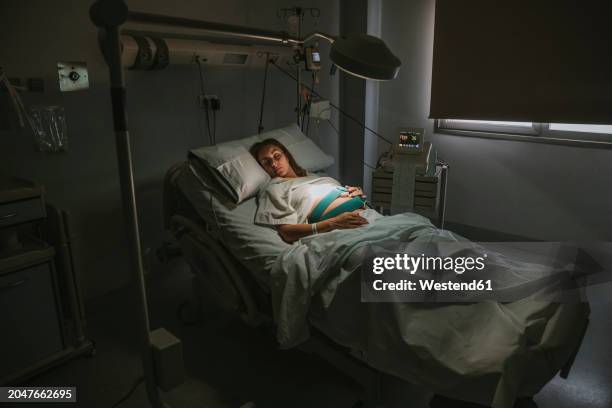 pregnant woman sleeping on bed near equipment in delivery room at hospital - hospice stock pictures, royalty-free photos & images