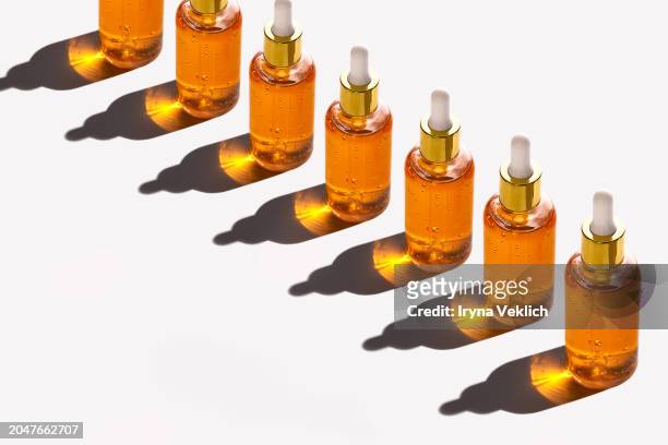 pattern of glass bottles with pipette and long shadows in pastel peach color on white color background. - ampoule dessin stockfoto's en -beelden