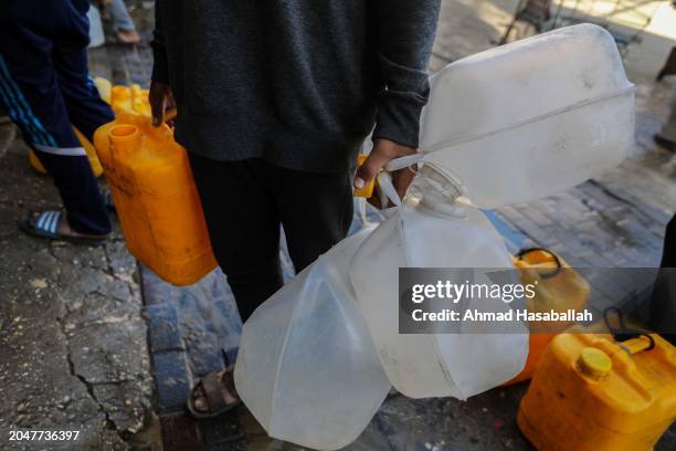 Palestinian citizens collect water from a water filling station as people suffer water shortages due to the war on February 29, 2024 in Rafah, Gaza....