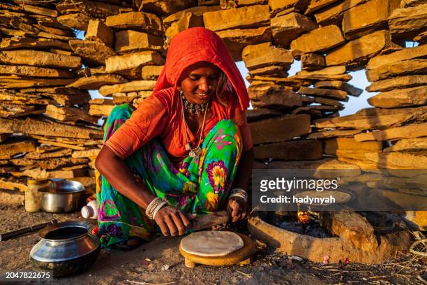 indian woman preparing food - chapatti, flat bread, desert village - brazier stock pictures, royalty-free photos & images