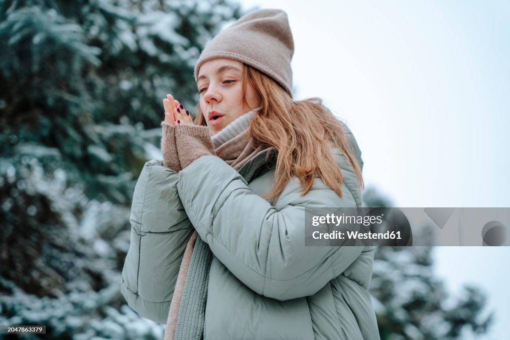 Woman warming up hands in winter