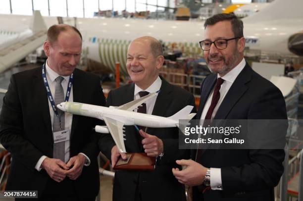 German Chancellor Olaf Scholz receives a model airplane as a gift from EFW CEO Jordi Boto and EFW CFO Kai Mielenz at the EFW Elbe Flugzeugwerke...