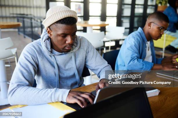 junge männliche college-studenten sitzen in einer cafeteria und arbeiten an einem laptop - technische hochschule stock-fotos und bilder