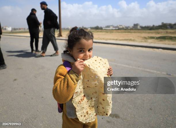 Palestinian child eats bread as Palestinians forced to relocate to the central and southern regions of the Gaza Strip, amidst hunger and to shield...